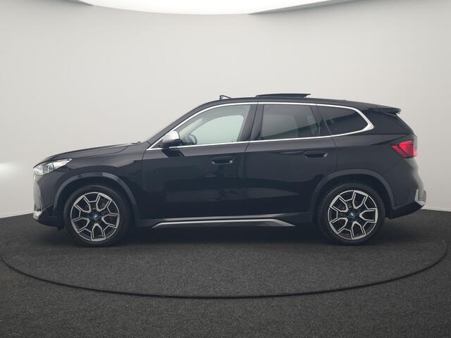 BMW iX1 xDrive30 X Line 67 kWh 313pk Dealer O.H. | Trekhaak Af Fabriek | Panodak | Head Up | Adaptive Cruise | 360 Camera | Harman / Kardon | Lederen Sportstoelen Massage & Memory | Keyless | Sfeerverlichting | Stoelen & Stuur Verwarmd | Apple Carplay | Widescreen Navi | DAB | 19"L.M |