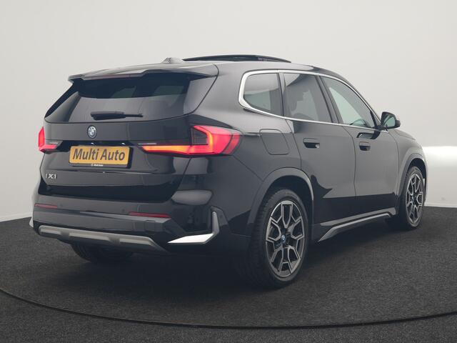 BMW iX1 xDrive30 X Line 67 kWh 313pk Dealer O.H. | Trekhaak Af Fabriek | Panodak | Head Up | Adaptive Cruise | 360 Camera | Harman / Kardon | Lederen Sportstoelen Massage & Memory | Keyless | Sfeerverlichting | Stoelen & Stuur Verwarmd | Apple Carplay | Widescreen Navi | DAB | 19"L.M |