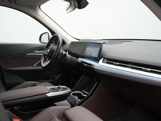 BMW iX1 xDrive30 X Line 67 kWh 313pk Dealer O.H. | Trekhaak Af Fabriek | Panodak | Head Up | Adaptive Cruise | 360 Camera | Harman / Kardon | Lederen Sportstoelen Massage & Memory | Keyless | Sfeerverlichting | Stoelen & Stuur Verwarmd | Apple Carplay | Widescreen Navi | DAB | 19"L.M |