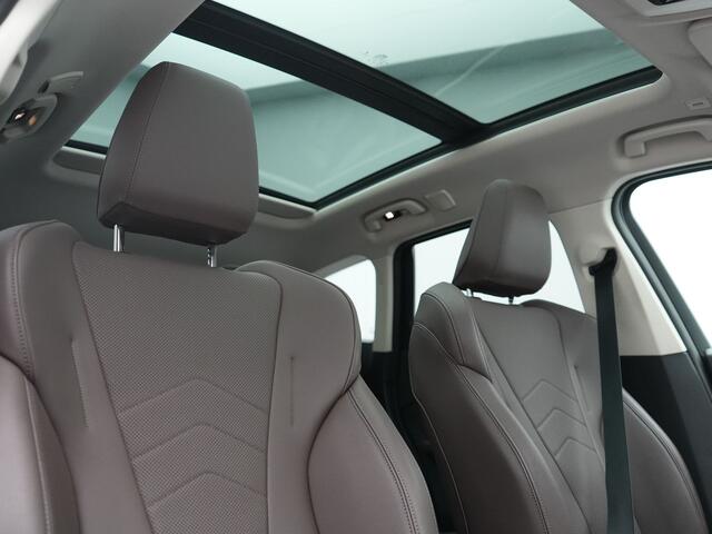 BMW iX1 xDrive30 X Line 67 kWh 313pk Dealer O.H. | Trekhaak Af Fabriek | Panodak | Head Up | Adaptive Cruise | 360 Camera | Harman / Kardon | Lederen Sportstoelen Massage & Memory | Keyless | Sfeerverlichting | Stoelen & Stuur Verwarmd | Apple Carplay | Widescreen Navi | DAB | 19"L.M |