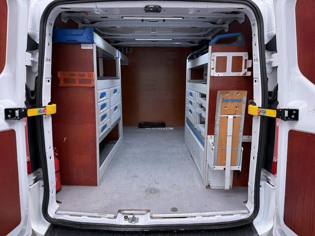 Ford TRANSIT CUSTOM 340 2.0TDCI 130PK L2H1 Sortimo Inperiaal+Ladder Trekhaak Cruise Control Airco Stoelverwarming Pdc Trend Betonplex Vloer Wandbetimmering Inbouwkasten Led