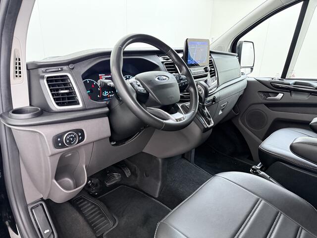 Ford TRANSIT CUSTOM 320 2.0TDCI 170PK Automaat L2H1 Dubbele Cabine 2X Schuifdeur Adap.Cruise 5-Persoons Leder+Verwarmd Trekhaak Navi Camera Pdc Apple Carplay/Android Auto Limited DC Euro 6 Lmv 18" Sidebars Betonplex Vloer Wandbetimmering Lane Assist 3.200KG Trekgewicht