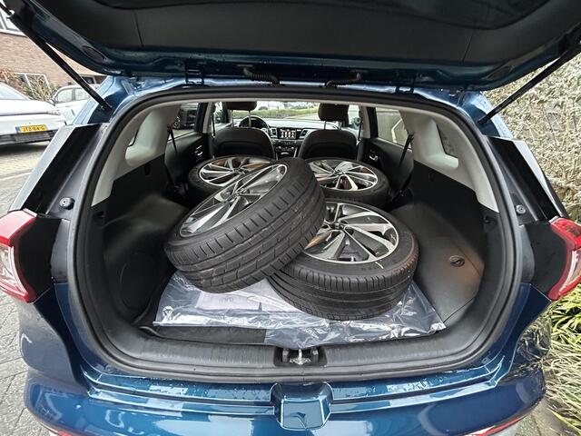 KIA Niro ExecutiveLine 1.6 GDi Hybrid 140PK Automaat Navigatie, Achteruitrijcamera, Stoelverwarming en Ventilatie, Stuurwielverwarming, Parkeersensoren, Trekhaak, Zomer en winterbandenset op lichtmetalen velgen.