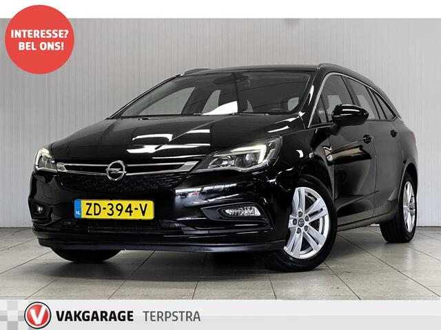 Opel ASTRA Sports Tourer 1.0 Business Executive/ Trekhaak/ 16'' LMV/ Keyless/ Apple + Android/ PDC V+A/ DAB+/ Navi/ Clima/ Cruise/ Elek. pakket/ Isofix/ Bluetooth/ Multi. LEDER. Stuur/ Mistl./ Chroom/ Dakrails.