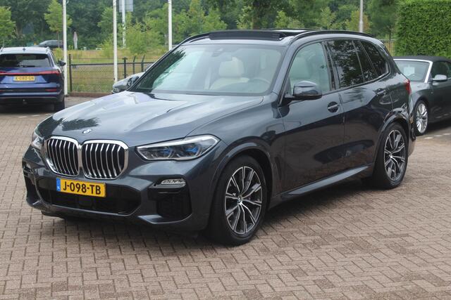BMW X5 xDrive30d High Exe. 7p. M Sport / Trekhaak / Panoramadak / Camera / Head-up / Softclose / 20'' / Harman Kardon / Luchtvering / Laser LED / Keyless / Leder / Apple CarPlay / Stuurverwarming / DAB / ACC / Zonnescherm zijruite