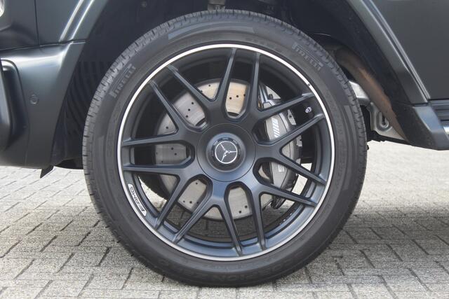 Mercedes-Benz G-KLASSE 63 AMG Night pakket/Magno matt/Panoramadak/Burmester audio/Sfeerverlichting/Entertainment schermen achter/Akrapovic/AMG active ride control/Elektrisch verstelbare stoelen met memory + massage/Stoel verwarming + koeling/360° camera/voorruitverwarming/IWC